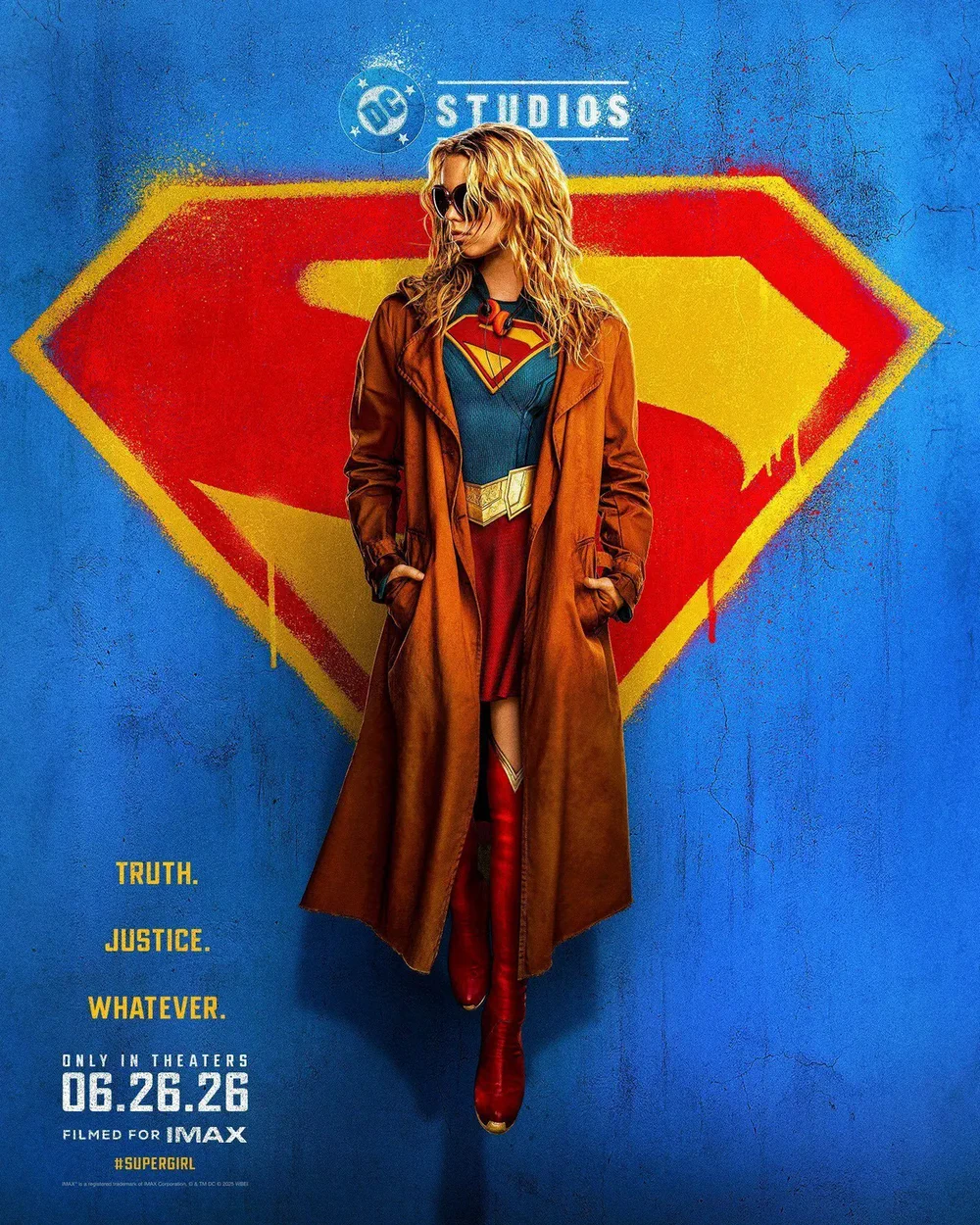 Фильм «Супергёрл» с изображением героини перед красным гербом DC